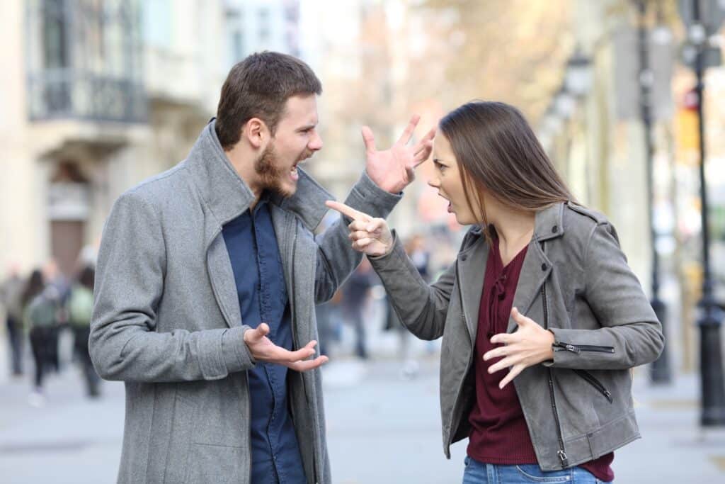 Un couple se disputant au milieu de la rue.