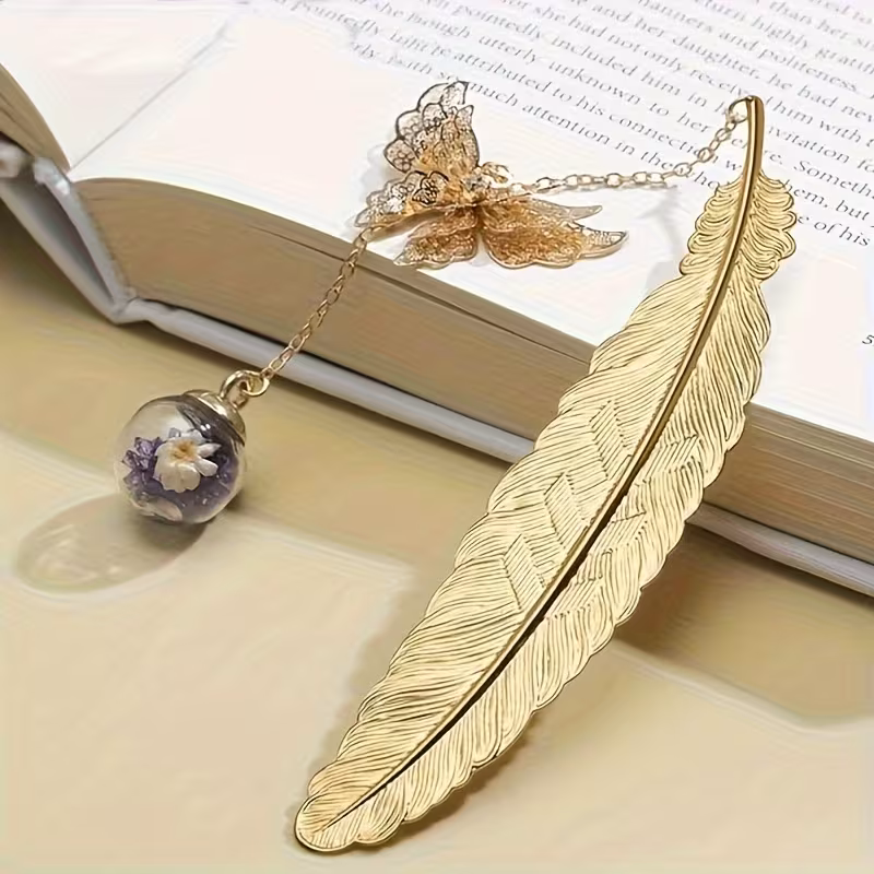 Marque-Page Plume et Papillon – Métal Couleur Or L'Élégance de l'Écrit, le Symbole de la Transformation Ce marque-page exquis n'est pas seulement un accessoire de lecture, c'est une pièce de joaillerie pour vos livres.