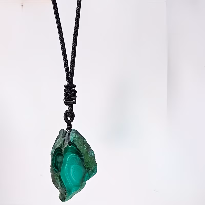 Pendentif artisanal en Malachite naturelle (tranche de minéral). Il agit sur le Chakra du Cœur pour briser le stress, favoriser la transformation et avertir du danger.